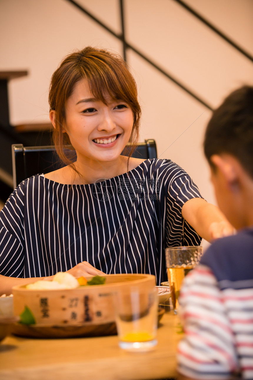 餐桌上微笑吃饭的女性图片