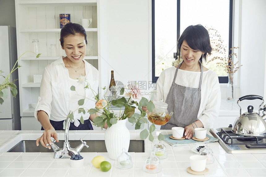 漂亮主妇在明亮的厨房里制作饮品图片