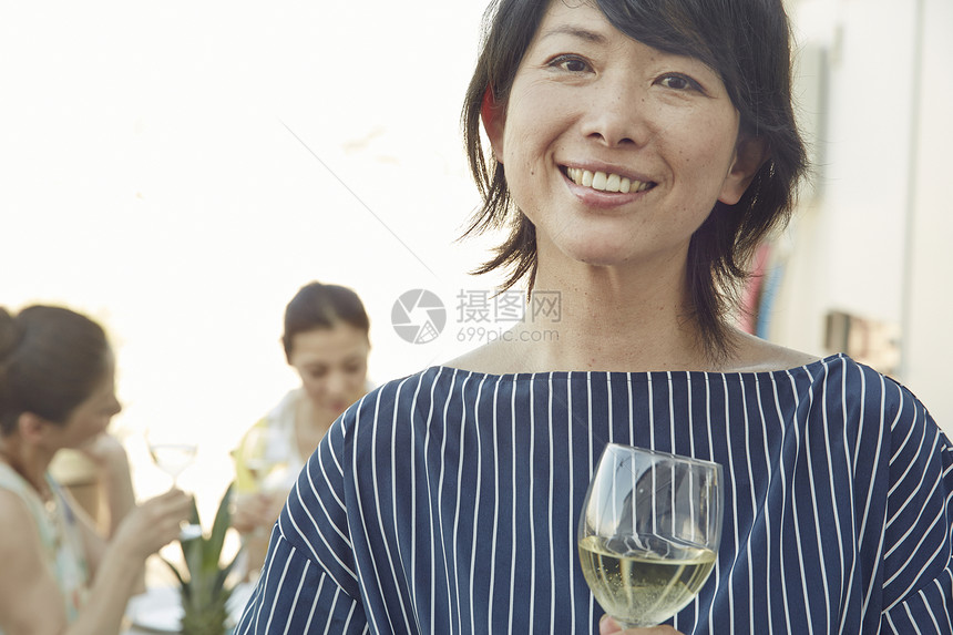 花园聚会手拿酒杯的女性形象图片