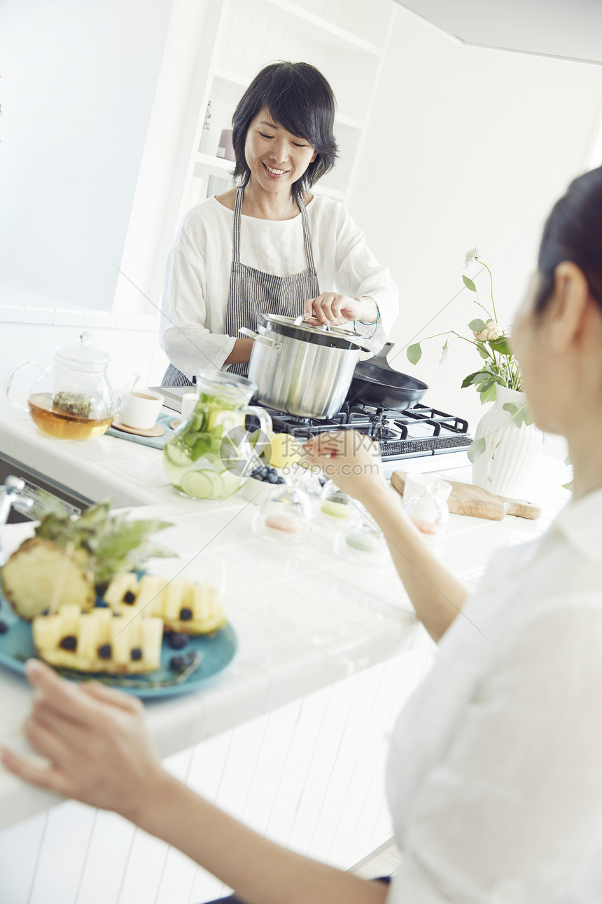 漂亮主妇在明亮的厨房里制作饮品图片