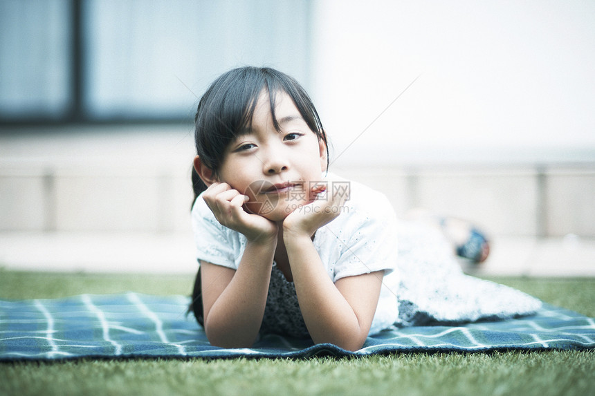 趴在草坪上的小女孩图片