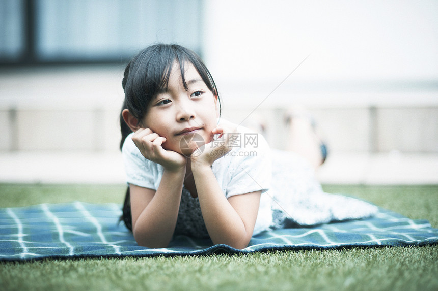 户外趴在草坪上的小女孩图片