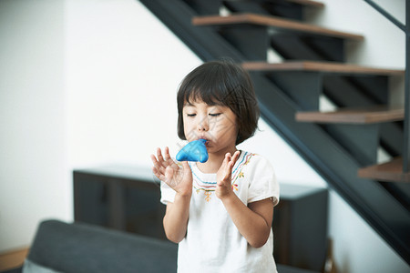 客厅里吹气球的小女孩背景图片