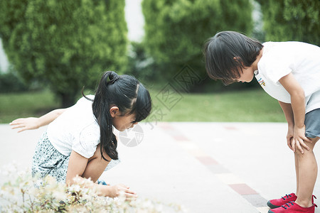 小女孩姐妹俩蹲在地上玩耍图片