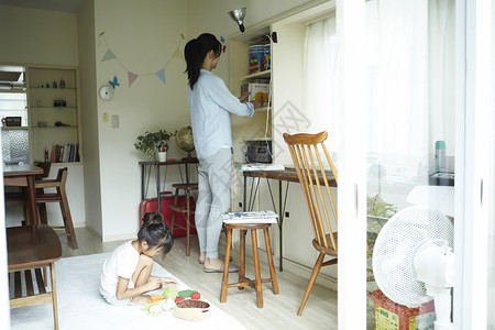 居家打扫的家庭主妇和独自玩耍的孩子图片