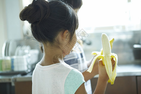 小女孩在家里吃香蕉图片