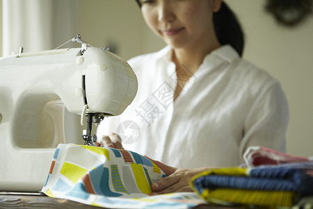 家庭妇女在缝纫机上缝衣服背景图片