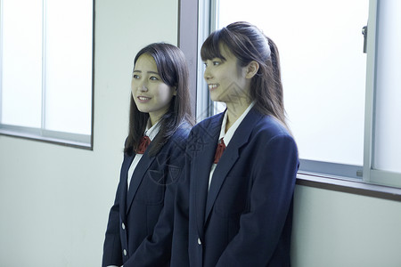 在学校的走廊里聊天的女高中学生图片
