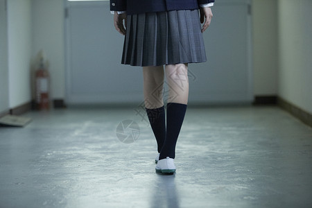 在学校走廊里的制服女高中生背景图片