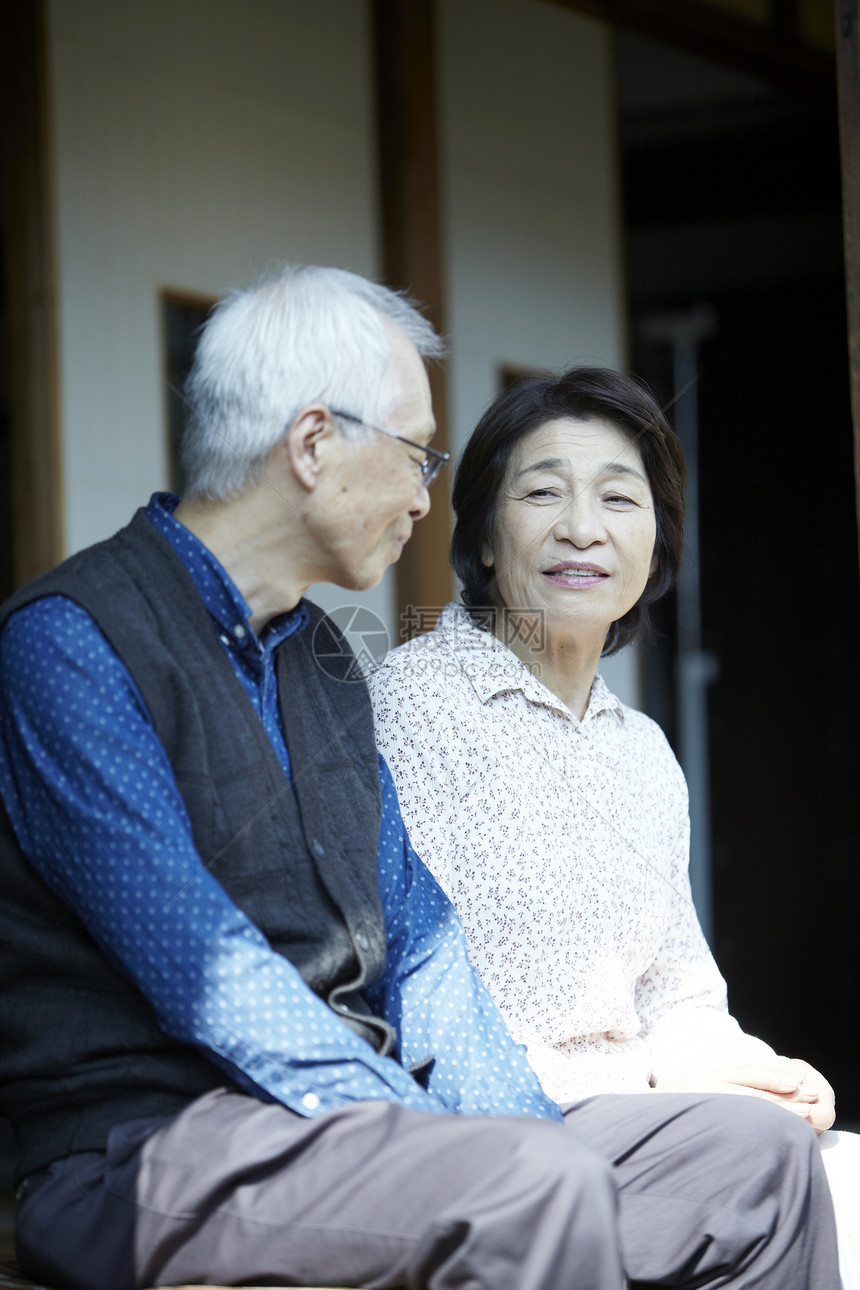 坐在屋外台阶上聊天的老夫妇图片