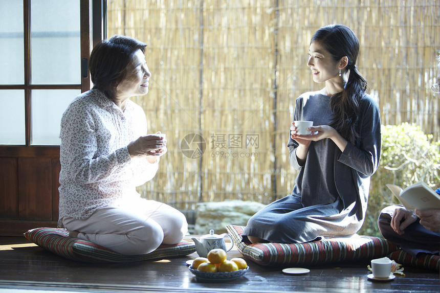 和女儿一起喝茶聊天的夫妇图片