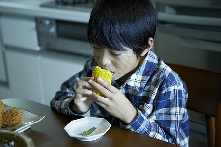掉进缸中男孩小男孩在吃玉米背景