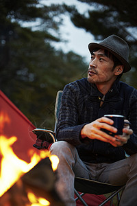 篝火旁放松的男人图片