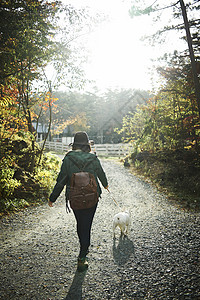 牵着宠物走在山道路上的妇女图片