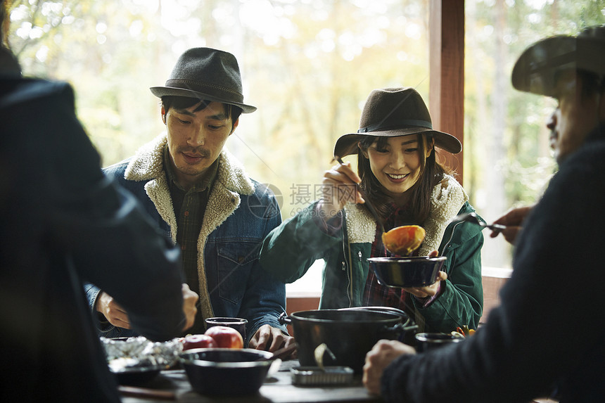 与朋友一起享用餐食的男女图片