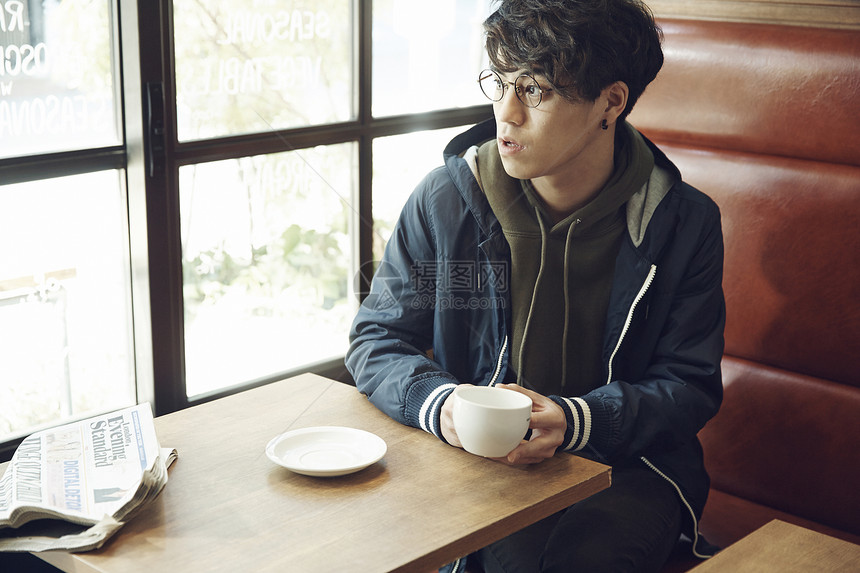 年轻男性一个人在咖啡馆喝咖啡图片