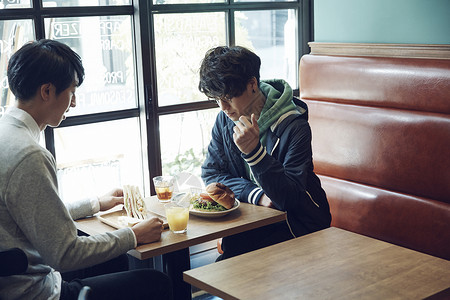 在咖啡馆吃午饭的青年男性图片