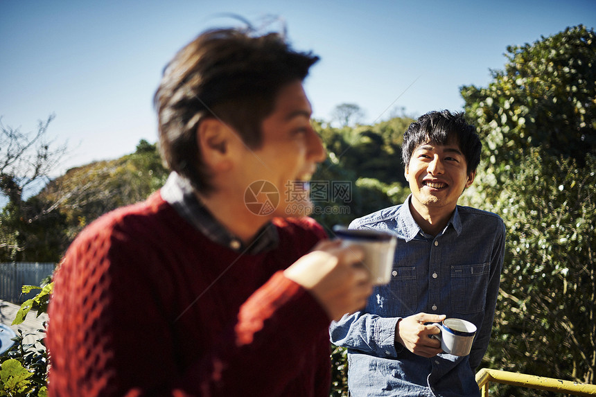 室外喝咖啡聊天的男性图片