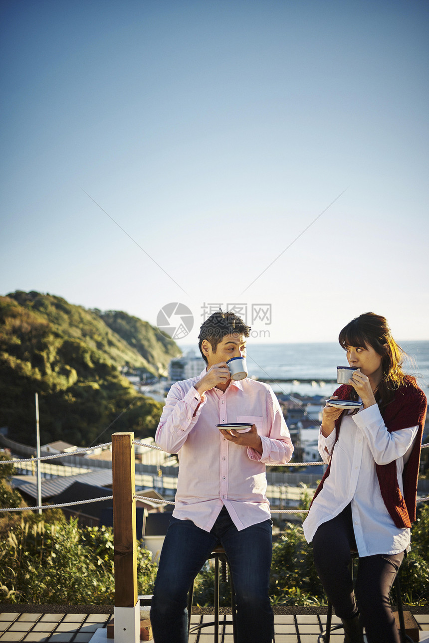户外栏杆喝咖啡的情侣图片