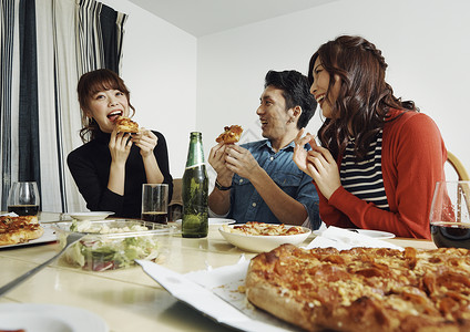 享受家庭聚会上美食的男人和女人图片