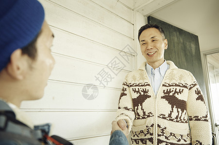 男人在门口迎接旅客入住图片