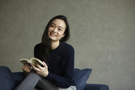 编辑书素材在沙发上读书的女人背景