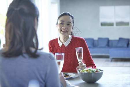 边吃午餐边交谈的年轻女子图片