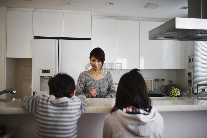 孩子们看着厨房里做饭的母亲图片