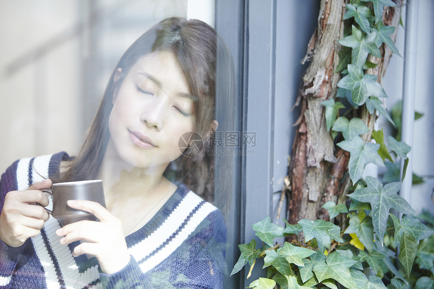 靠在窗边喝咖啡的女生图片