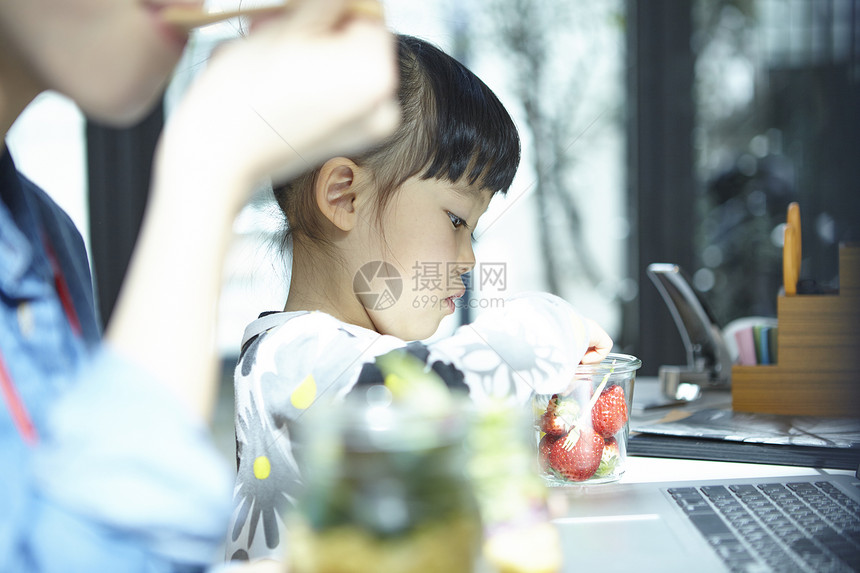 小女孩在妈妈的办公室吃午餐图片
