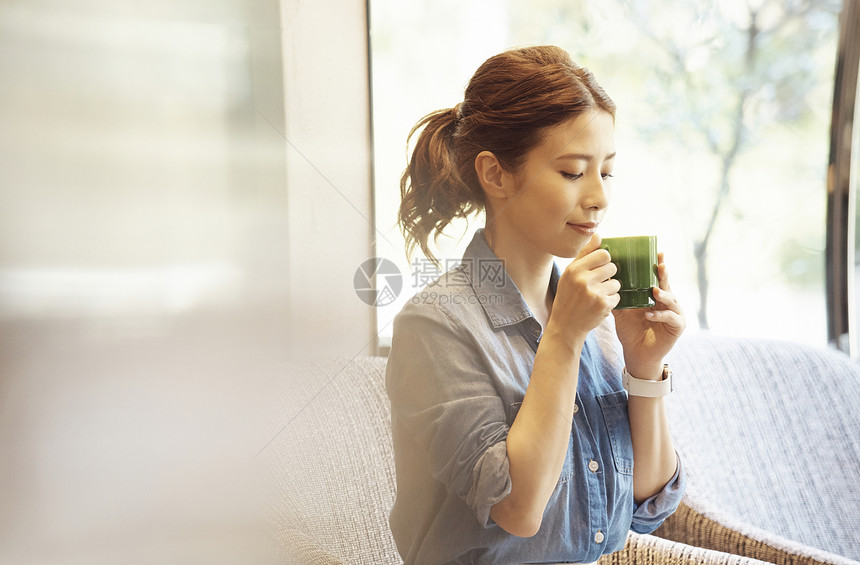 一个女人坐在窗边喝咖啡图片