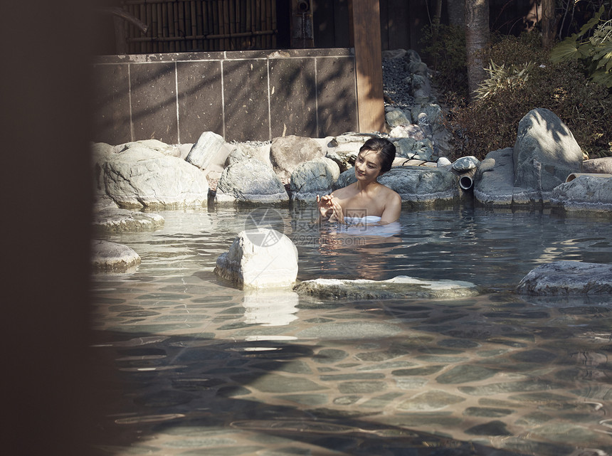 一个女人沉浸在温暖的温泉里图片