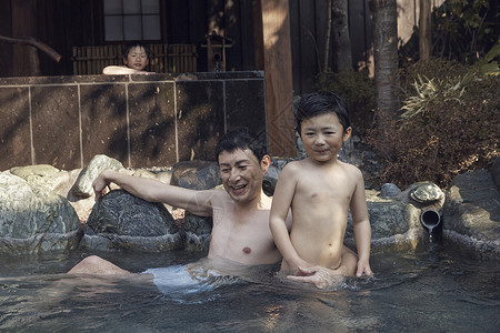 父亲和孩子在户外浴池泡澡图片