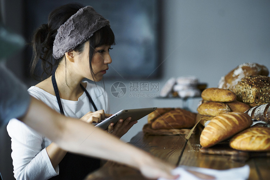 户内男早餐使用平板电脑的女人图片