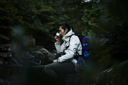 在山间喝水的男人图片
