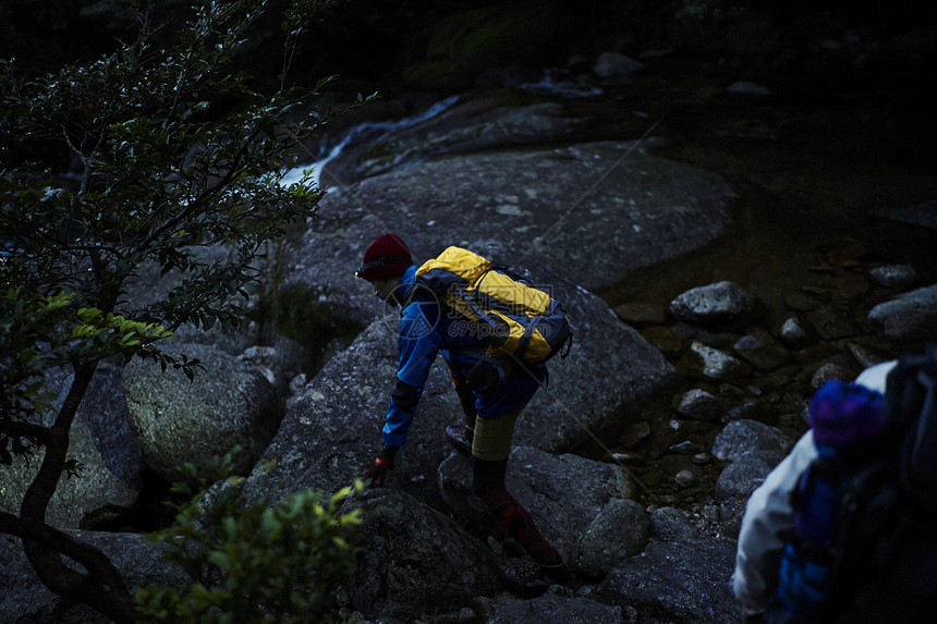 晚上走在森林中的男背包客图片