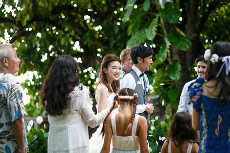 海外婚礼仪式举办室外草坪婚礼新婚夫妇和亲朋好友背景