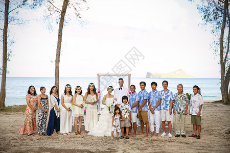 举办海滩婚礼的新婚夫妻和亲朋好友图片