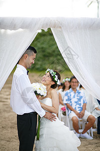 海外婚礼仪式举办海滩婚礼的新婚夫妇背景