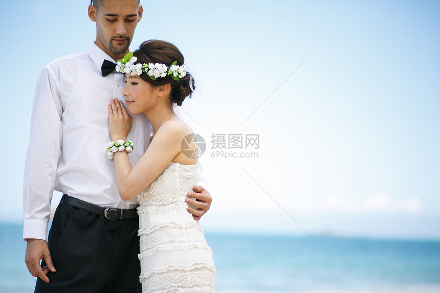 海滩边拥抱的新婚夫妻图片