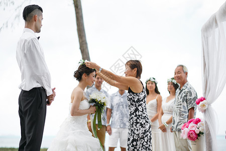 举办海滩婚礼的新婚夫妇和亲朋好友图片