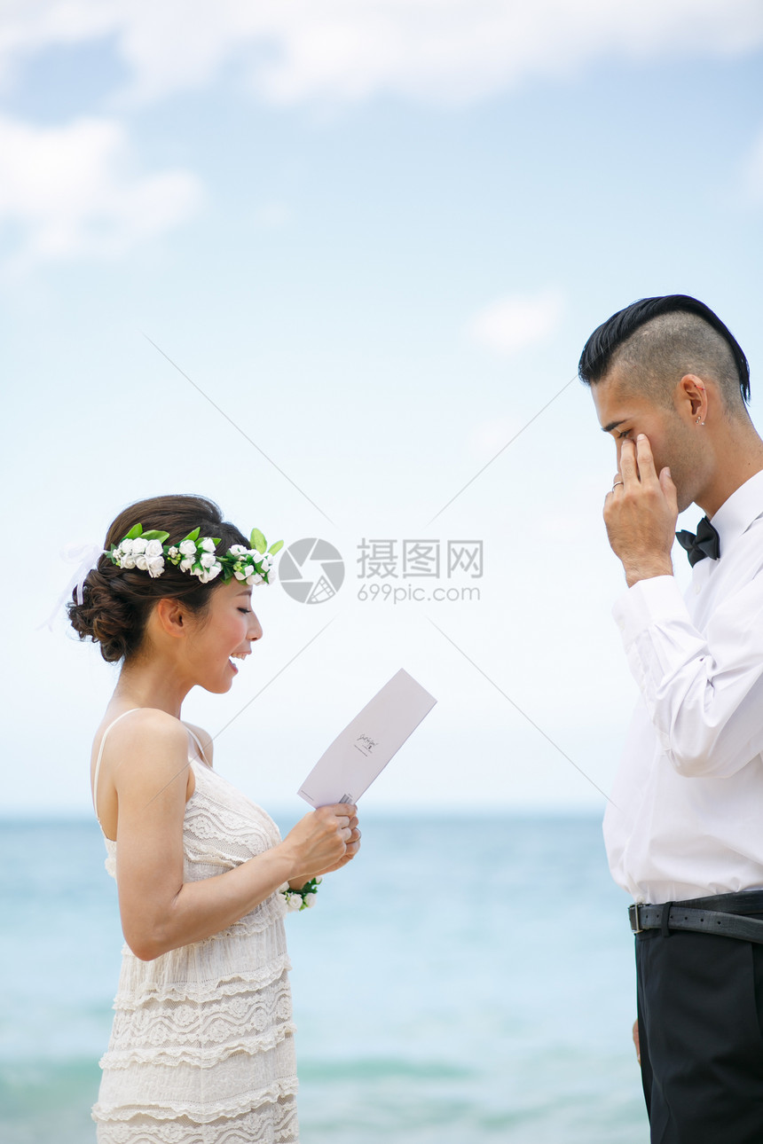 海滩边宣读誓言的新婚夫妻图片