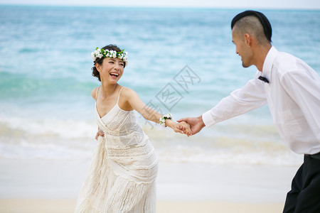 海滩边牵手的新婚夫妻图片