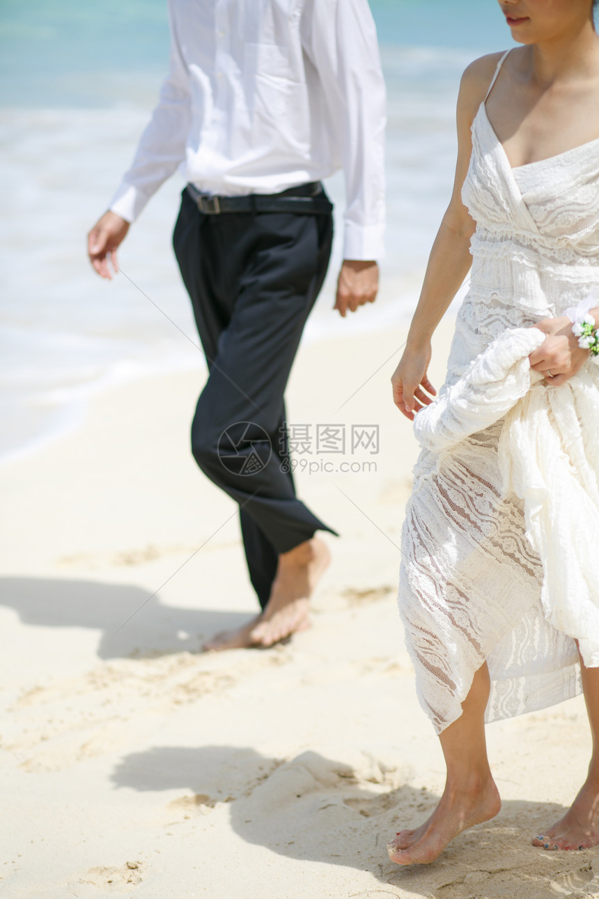 海滩边奔跑的新婚夫妻特写图片