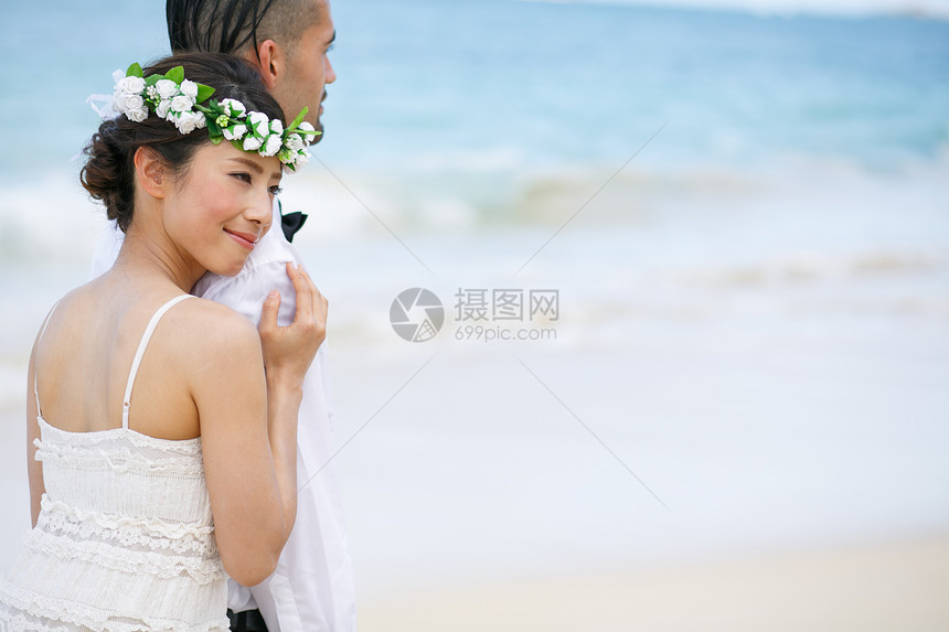 海滩边拥抱的新婚夫妻图片