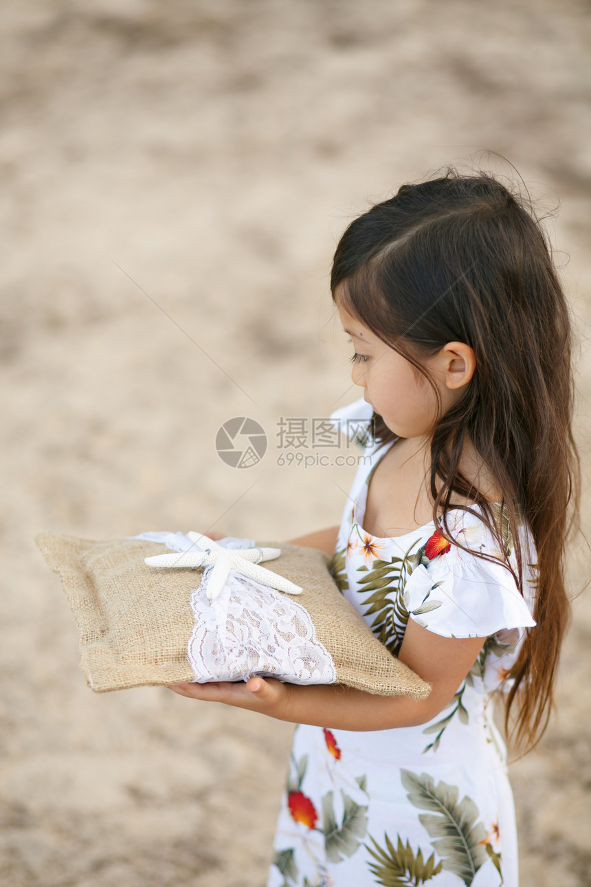 沙滩上手拿礼物的小女孩图片