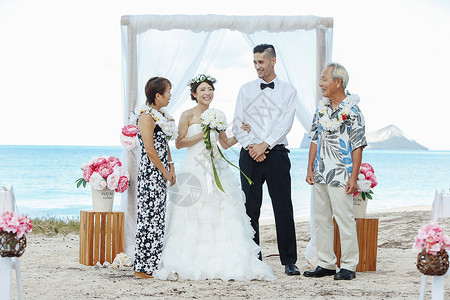 举办海滩婚礼的新婚夫妇与长辈图片
