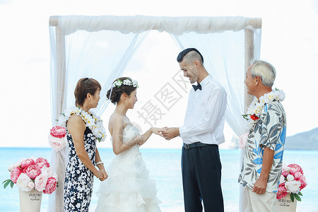 海外婚礼仪式新娘和新郎进行海滩婚礼背景