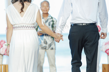 海滩婚礼牵手的新婚夫妻图片