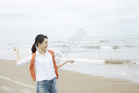 一个女人在海边扔石子享受旅行图片